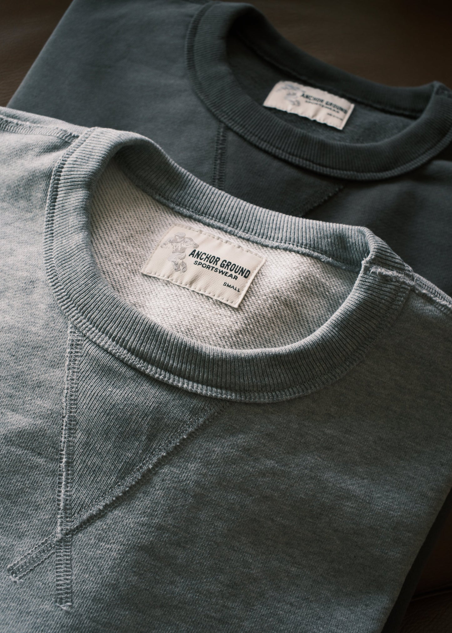 Close-up of a gray sweatshirt with a brand label on a dark surface