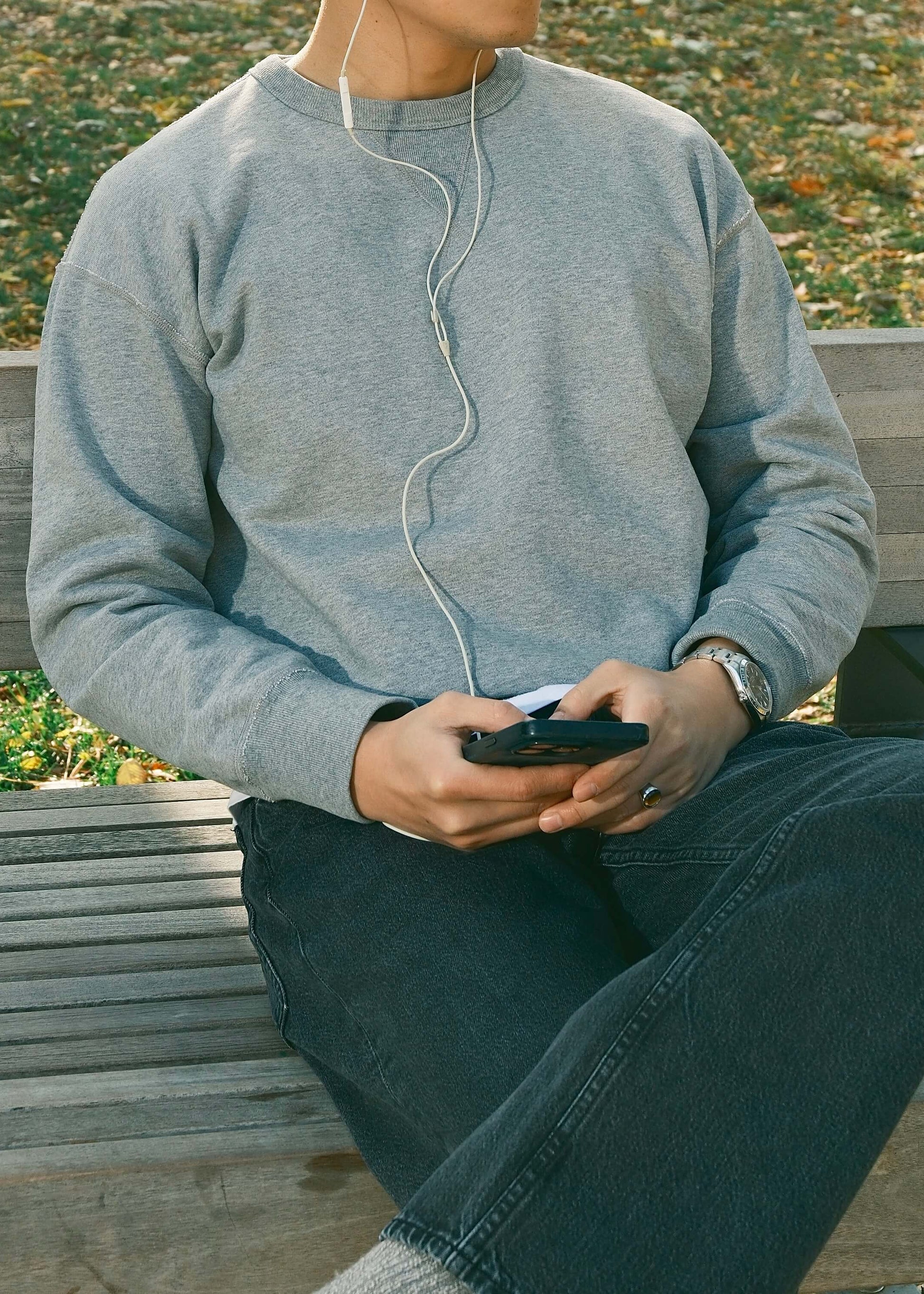 Light grey crewneck sweatshirt styled casually with dark jeans.