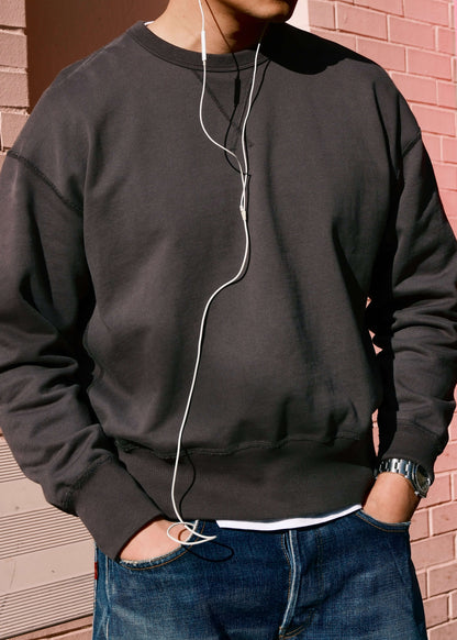 Black crewneck sweatshirt for men, shown layered over white tee in outdoor setting.